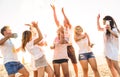 Group of happy friends having fun at beach party on holi colors