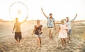 Group of happy friends having fun on the beach at sunset Royalty Free Stock Photo