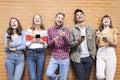 Group of happy friends having fun with mobile smartphones outdoors - Young people laughing together during break at university Royalty Free Stock Photo