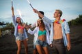 Group of friends having fun running on the beach with sparklers Royalty Free Stock Photo