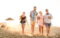 Group of happy friends having fun at seaside sunset - Summer vacations and friendship concept with young people millennials Royalty Free Stock Photo