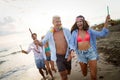 Group of happy friends having fun walking down the beach at sunset Royalty Free Stock Photo