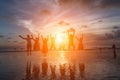 Group of happy friends jumping on beach against sunset Royalty Free Stock Photo