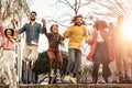 Group of happy friends jumping outdoor - Millennial young people having fun dancing and celebrating at sunset outside Royalty Free Stock Photo