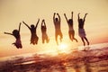 Group of happy friends jumps in sunset water Royalty Free Stock Photo