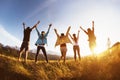 Group happy friends mountains sunset raised arms Royalty Free Stock Photo