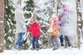 Group of happy friends playing snowballs in forest