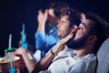 Group of happy friends sitting in cinema watch film and eating popcorn Royalty Free Stock Photo