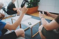 Group of happy friends sitting on a sofa in living room and playing video games. Family relaxing time at home concept. Royalty Free Stock Photo