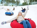 Group of happy friends sliding down on snow tubes Royalty Free Stock Photo