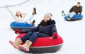 Group of happy friends sliding down on snow tubes Royalty Free Stock Photo