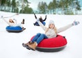 Group of happy friends sliding down on snow tubes Royalty Free Stock Photo