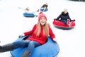 Group of happy friends sliding down on snow tubes Royalty Free Stock Photo