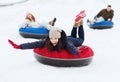 Group of happy friends sliding down on snow tubes Royalty Free Stock Photo