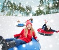 Group of happy friends sliding down on snow tubes Royalty Free Stock Photo