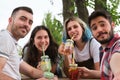 Group of happy friends smiling and taking a selfie while drinking refreshing drinks in a park Royalty Free Stock Photo