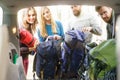 Group of happy friends taking their bags from a car to start a hike . Royalty Free Stock Photo