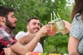 Group of happy friends toasting, having fun, drinking and eating fruit in a park Royalty Free Stock Photo