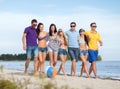 Group of happy friends walking along beach Royalty Free Stock Photo