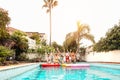 Group happy friends wearing mask making pool party - Young people having fun celebrating event in exclusive swimming pool Royalty Free Stock Photo