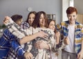 Group of happy, funny school friends playing, hugging, and having fun in the classroom Royalty Free Stock Photo