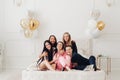 Group of happy girl friends laughing posing on bed enjoying pajamas party