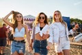 Group of happy girls at beach festival in summer, friends dance, enjoy music, sunny day. Women in trendy attire Royalty Free Stock Photo