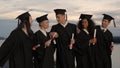 Group of happy graduates walking to graduation ceremony in the e Royalty Free Stock Photo