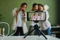 Group of happy intercultural kids performing song on smartphone screen