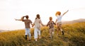 Group of happy joyful school kids boys and girls running with their backs in field on sunny day Royalty Free Stock Photo