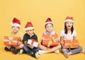 Group of happy kids in Christmas hat with presents