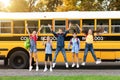 Group of happy kids jumping in front of school bus outdoors Royalty Free Stock Photo