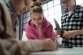 Group of kids working together on project with electric toys and robots at robotics classroom, close up for girl Royalty Free Stock Photo