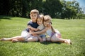 Group of happy little children smiling sitting in park on grass. friendship, childhood, vacation.