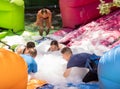 Group of happy men and women swimming in foam pool in adventure park Royalty Free Stock Photo