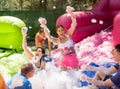 Group of happy men and women swimming in foam pool in adventure park Royalty Free Stock Photo