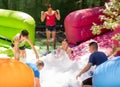 Group of happy men and women swimming in foam pool in adventure park Royalty Free Stock Photo