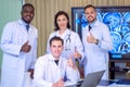 Group Of Happy multicultural doctors showing thumbs up and smiling on camera while posing at conference room. Portrait of Royalty Free Stock Photo