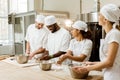 group of happy multiethnic bakers kneading Royalty Free Stock Photo