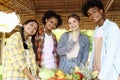 Group of happy Multiethnic teenager friend holding organic food products from their own farm at local market fair, smiling young Royalty Free Stock Photo