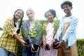 Group of happy Multiethnic teenager friend holding sapling tree, smiling young diverse farmer preparing for planting and having Royalty Free Stock Photo