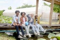 Group of happy Multiethnic teenager friend working in vegetable farm together, smiling young diverse farmer sitting together