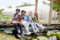 Group of happy Multiethnic teenager friend working in vegetable farm together, smiling young diverse farmer sitting together