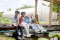 Group of happy Multiethnic teenager friend working in vegetable farm together, smiling young diverse farmer sitting together