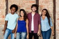 Group of happy multiethnic young men and women indoor looking at Royalty Free Stock Photo