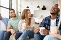 Group of happy multiracial friends drinking coffee in living room, having conversation, enjoying time together Royalty Free Stock Photo