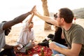 Group of happy multiracial friends having fun together on the beach, playing cards on picnic, laughing. Mixed race people Royalty Free Stock Photo