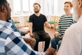 Group of happy multiracial people holding hands sitting in circle during therapy session. Cheerful multicultural and Royalty Free Stock Photo
