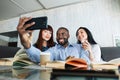 Group of happy multiracial young friends sitting at the cafe after classes or work and relaxing on coffee break with Royalty Free Stock Photo