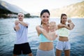 Group of happy people exercising outdoor. Sport, fitness, friendship and healthy lifestyle concept